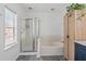 Bathroom showcasing a glass shower, bathtub, and linen cabinet with wooden finishes at 3202 Middleburry Ln, Charleston, SC 29414
