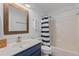 Bathroom with a wood-framed mirror, blue vanity, and a shower with striped curtain at 3202 Middleburry Ln, Charleston, SC 29414