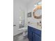 Half-bathroom features a bright blue vanity, a decorative mirror, and a sun-filled window at 3202 Middleburry Ln, Charleston, SC 29414