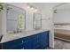 Double vanity bathroom with white countertops, stylish blue cabinets, and dual mirrors offers contemporary luxury at 3202 Middleburry Ln, Charleston, SC 29414