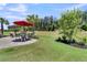 Landscaped backyard featuring a patio with dining under a red umbrella and lush green lawn at 467 Hidden Meadow Ln, Summerville, SC 29486