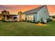 The backyard shows a patio area with a fire pit, grill, palm trees and well-manicured grass at 467 Hidden Meadow Ln, Summerville, SC 29486