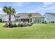 Spacious backyard featuring a patio, lush lawn, tropical palm trees, and beautiful landscaping at 467 Hidden Meadow Ln, Summerville, SC 29486