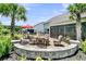 Backyard patio featuring a fire pit with seating area and an outdoor dining table with a red umbrella at 467 Hidden Meadow Ln, Summerville, SC 29486