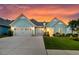 Beautiful home showcasing an expansive driveway and three-car garage, complemented by a lush green lawn at 467 Hidden Meadow Ln, Summerville, SC 29486
