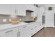 Kitchen with white cabinets, a gas stove, and gray backsplash, complemented by dark wood floors at 467 Hidden Meadow Ln, Summerville, SC 29486