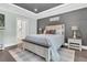 Well-lit main bedroom showcasing a gray accent wall, a large bed, and elegant decor at 467 Hidden Meadow Ln, Summerville, SC 29486