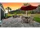 Outdoor patio featuring a dining area, fire pit, and lush landscaping against a vibrant sunset at 467 Hidden Meadow Ln, Summerville, SC 29486