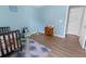 Cozy Bedroom with light blue walls, hardwood floor, and neutral rug with assorted toys on display at 4801 Shady Tree Ln, Summerville, SC 29485