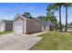 Spacious detached garage and rear of the home with a screened porch and neutral siding at 4801 Shady Tree Ln, Summerville, SC 29485