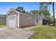Detached garage with a white door and neutral siding, located behind the house at 4801 Shady Tree Ln, Summerville, SC 29485