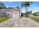 View of a garage, and the home, featuring a driveway and surrounding trees at 4801 Shady Tree Ln, Summerville, SC 29485