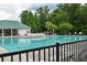 A long, luxurious swimming pool with lounge chairs is surrounded by a black fence and a pool house at 4936 Ballantine Dr, Summerville, SC 29485