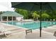 Inviting community swimming pool features a covered picnic area, umbrellas, and lounge chairs under a large shade umbrella at 4936 Ballantine Dr, Summerville, SC 29485