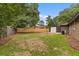 Backyard showcasing a brick home, new wooden fence, detached garage and grassy area at 4965 Foxwood Dr, North Charleston, SC 29418