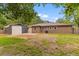 Spacious backyard with a brick house, storage shed, and lush green grass at 4965 Foxwood Dr, North Charleston, SC 29418