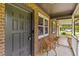 Inviting front porch featuring cozy wicker seating and a charming brick facade at 4965 Foxwood Dr, North Charleston, SC 29418
