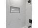 Elegant shower with white marble tiling, a black shower head, and a convenient built-in storage niche at 4965 Foxwood Dr, North Charleston, SC 29418