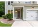 View of the home's front entrance, landscaping, covered porch, and a two-car garage at 5001 Hay Bale Ct, Summerville, SC 29485