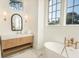 Bright bathroom featuring a soaking tub, vanity with sink, and large window at 515 Claret Way, Kiawah Island, SC 29455