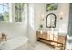 Bright bathroom featuring a soaking tub, vanity with sink, and large window at 515 Claret Way, Kiawah Island, SC 29455