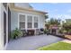 Cozy back patio with outdoor seating, fireplace, grill, and lush landscaping at 525 Scholar Way, Summerville, SC 29486