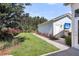 Backyard with grass and colorful flowerbeds leading to outdoor kitchen with tv at 525 Scholar Way, Summerville, SC 29486
