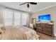 Serene bedroom with a ceiling fan, a large window, and a wood dresser with a TV at 525 Scholar Way, Summerville, SC 29486