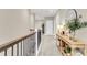 Upstairs hallway with wood railing, decorative iron spindles, and a console table with decorative items at 525 Scholar Way, Summerville, SC 29486