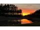 Scenic pond reflecting a vibrant sunset and silhouetted trees for a tranquil view at 525 Scholar Way, Summerville, SC 29486