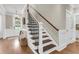 Elegant staircase with wooden steps and a wrought iron railing leading to the upper level at 525 Scholar Way, Summerville, SC 29486