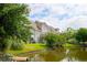 Backyard view of townhome with scenic lake, mature trees and lush landscaping at 543 Mclernon Trce, Johns Island, SC 29455