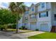 Exterior street view of well-maintained townhomes featuring attached garages and lush landscaping at 543 Mclernon Trce, Johns Island, SC 29455