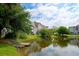 Community pond view with lush green landscaping and multi-story buildings in the background at 543 Mclernon Trce, Johns Island, SC 29455