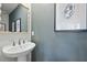Stylish powder room with blue-gray walls, framed prints, decorative mirror, and sink at 562 Scholar Way, Summerville, SC 29486