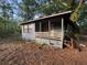 A modest, blue, single-story house with a small porch nestled in a wooded lot at 7112 Old Jacksonboro Rd, Ravenel, SC 29470