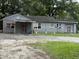 Charming single-story home with gray exterior and a spacious front yard surrounded by mature trees at 715 Yew St, Charleston, SC 29407