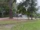 Charming home behind chain-link fence, surrounded by mature trees and a well-maintained lawn at 715 Yew St, Charleston, SC 29407