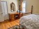 Charming bedroom featuring a four-poster bed, wooden desk, hardwood floors, and ample natural light streaming through shuttered windows at 946 Law Ln, Mount Pleasant, SC 29464