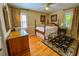 Comfortable bedroom with hardwood floors, a classic bed, wooden dresser and bright windows with decorative curtains and natural light at 946 Law Ln, Mount Pleasant, SC 29464