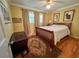 Cozy bedroom features a traditional wood-frame bed, neutral walls, hardwood floors, and a dark wood dresser with vintage charm at 946 Law Ln, Mount Pleasant, SC 29464