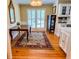 Traditional dining area with hardwood floors, a decorative rug, shuttered windows, and elegant furnishings under a chandelier at 946 Law Ln, Mount Pleasant, SC 29464