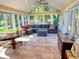 Light-filled sunroom showcasing a comfortable sectional sofa, tile flooring, and expansive windows with outdoor views and a ceiling fan at 946 Law Ln, Mount Pleasant, SC 29464