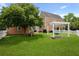 Spacious yard featuring shade trees, pergola swing, patio, and firepit with a white picket fence at 101 Barberry St, Summerville, SC 29483