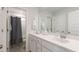 Well-lit bathroom with a large mirror, white vanity, and shower with a gray shower curtain at 1034 Scotch Bonnet Way, Summerville, SC 29485