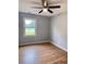 Bright bedroom with hardwood floors, a ceiling fan, and a large window overlooking the neighborhood at 105 Dandridge Rd, Walterboro, SC 29488