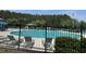 Community pool with lounge chairs, palm trees and a forest in the background on a sunny day at 107 Brookhaven Rd, Summerville, SC 29486