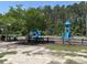 Community playground with several slides, swings and green trees on a sunny day at 107 Brookhaven Rd, Summerville, SC 29486