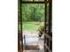 View from the screened-in porch to the backyard, featuring trees, a creek, and flowers in pots at 107 Twin Tree Dr, Summerville, SC 29485