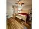 Bedroom with wood floors, a wicker bed, chest, shelving, and door to the hallway at 107 Twin Tree Dr, Summerville, SC 29485